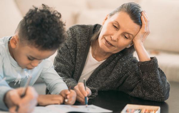 A photo of a guardian helping a child with homework where both look stressed