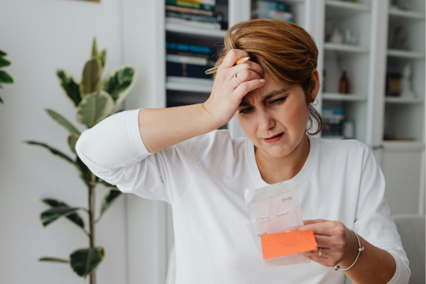 Woman holding a receipt looking stressed