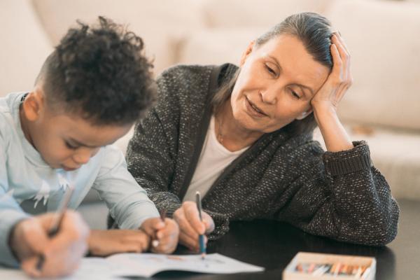 A photo of a guardian helping a child with homework where both look stressed